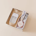 Load image into Gallery viewer, Lavender and Pine Glow and Go Gift Box angle view featuring Touchland Beach Coco Power Mist, Lanolips 101 ointment, and Prosecco Bears in mini tuck top gift box