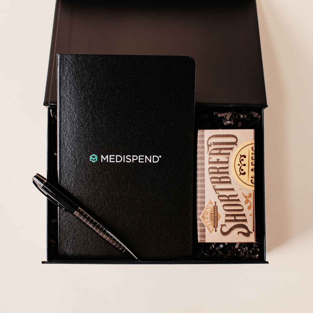 Custom branded gift box featuring a MEDISPEND® notebook, pen, and shortbread cookies, designed by Lavender + Pine for corporate gifting.