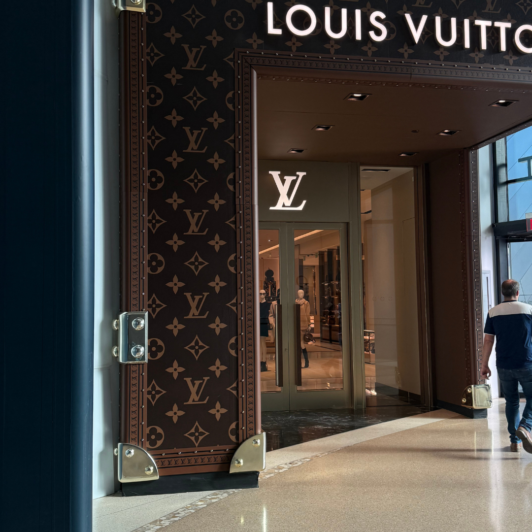 Louis Vuitton storefront entrance with signature monogram detailing, used to illustrate a story about luxury packaging and client gifting expectations by Lavender and Pine
