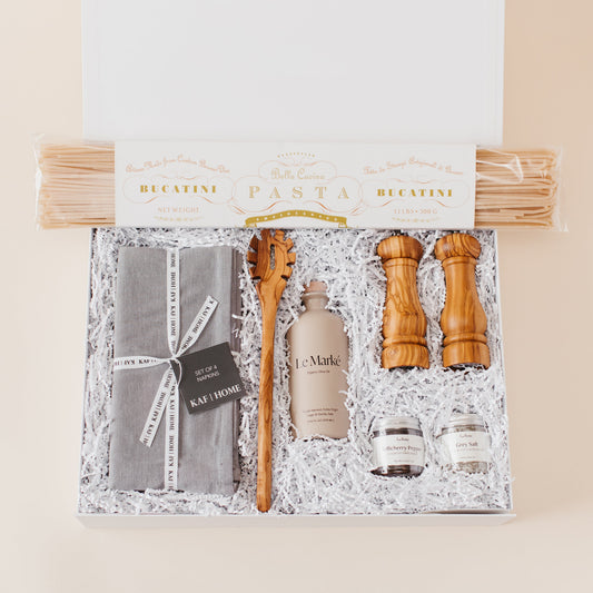 Lavender and Pine Cacio e Pepe Gift Box featuring Bella Cucina bucatini pasta, Le Marké olive oil, Natural OliveWood salt and pepper mills, pasta spoon, La Boite grey salt and Tellicherry pepper, and Kaf Home grey linen napkins in white magnetic gift box