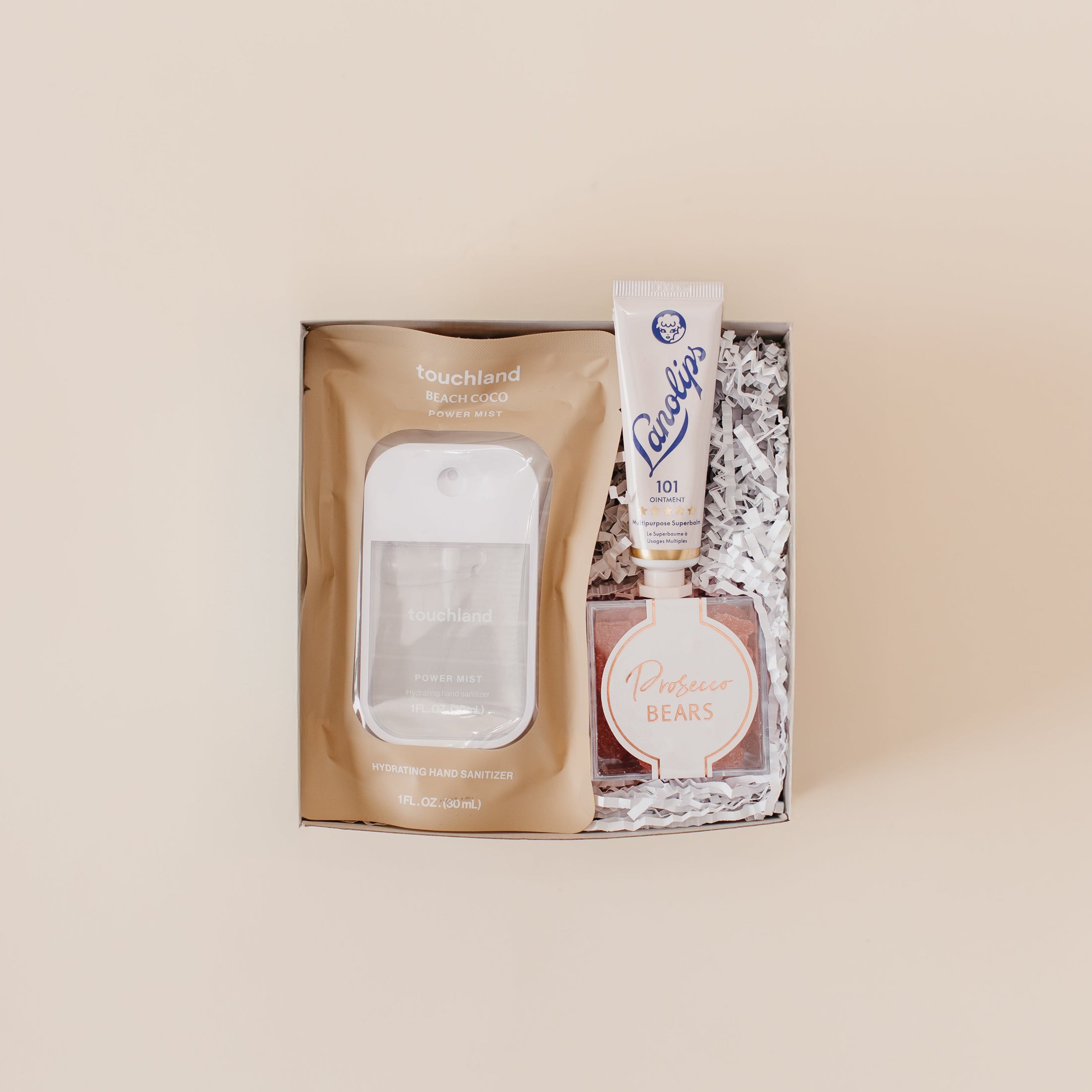 Lavender and Pine Glow and Go Gift Box featuring Touchland Beach Coco Power Mist, Lanolips 101 ointment, and Prosecco Bears in mini tuck top gift box