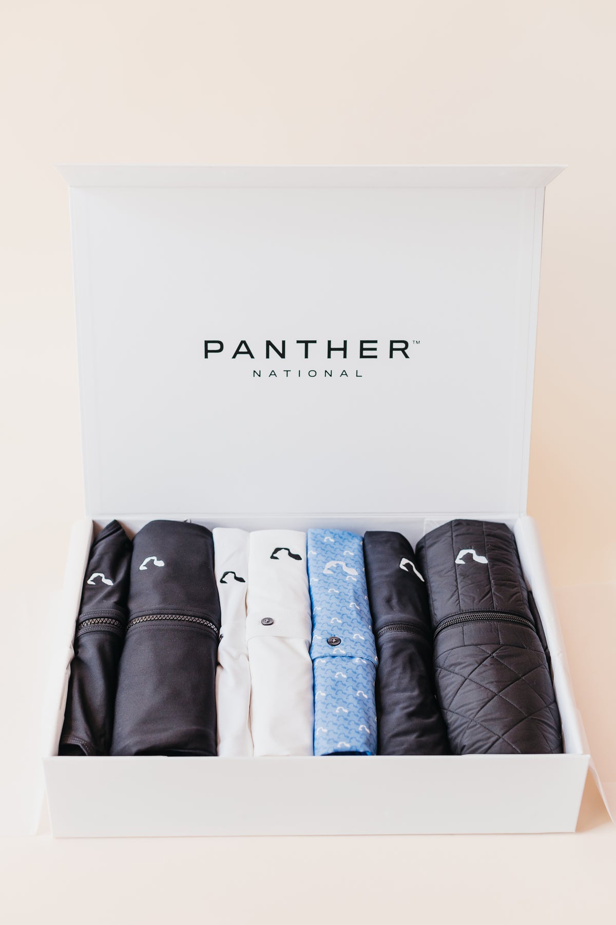 Open branded gift box with folded custom apparel items inside