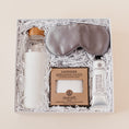 Load image into Gallery viewer, Lavender and Pine Soft Reset Gift Box featuring Soma glass water bottle, Pure Sol silk sleep mask, ElizabethW lavender exfoliating shower pouch, and ElizabethW lavender shea butter hand cream in white luxe two piece gift box
