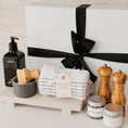 Load image into Gallery viewer, Lavender and Pine Well-Kept Kitchen Gift Box styled view featuring Homecourt Cece dish soap, dish brush set, Monaco kitchen towels, Natural OliveWood salt and pepper mills, La Boite Tellicherry pepper and grey salt, and Luxe B Co sandstone trivet riser in white magnetic gift box
